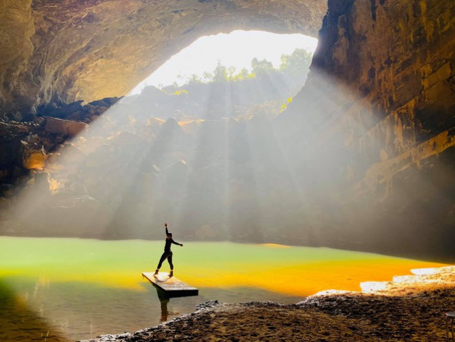 Morning sunlight inside Hang En with reflections on the underground river.