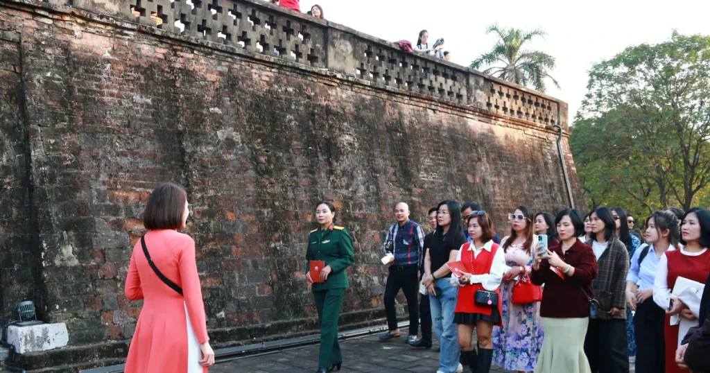 Private tour group listening to historical explanations at Nhan Tower